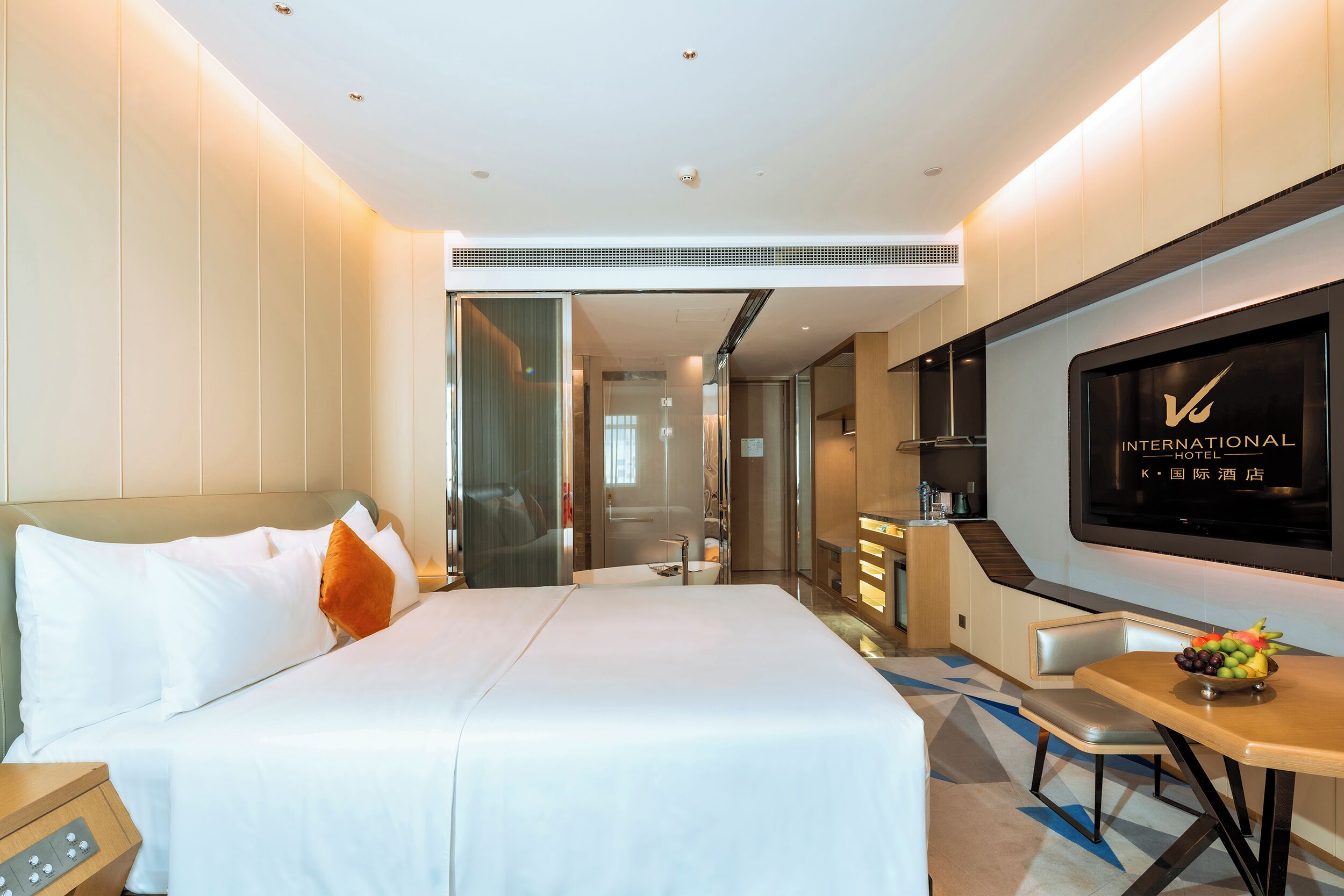A hotel room with a bed, a TV, a desk, and a chair.
