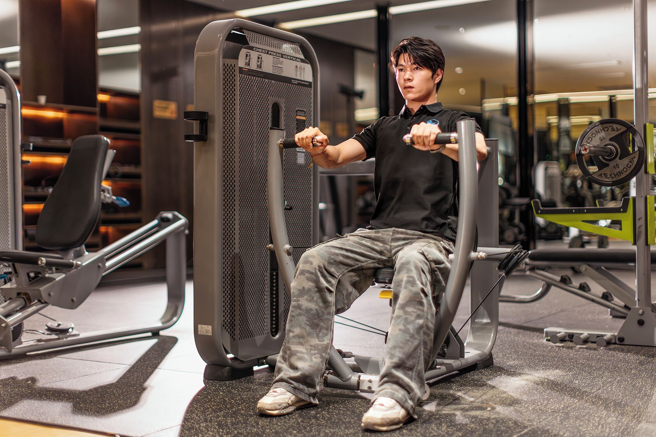 A gym with exercise equipment, including a chest press machine and a weight stack.