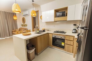 A modern kitchen with wooden cabinets, a built-in microwave, a stove, and a refrigerator.