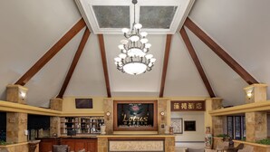 A spacious lobby with a high ceiling, a chandelier, and a reception desk.