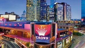 A hotel with a prominent 'Crown' sign, surrounded by modern high-rise buildings and a busy street. - Marvellous Views - Bright & Spacious CBD Escape (Melbourne)