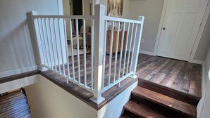 A staircase with wooden steps and white railings, leading to an upper floor. - In the middle of it all in French Lick!  (French Lick)