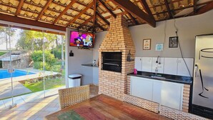 Een moderne keuken met een bakoven, een televisie en uitzicht op een zwembad.
