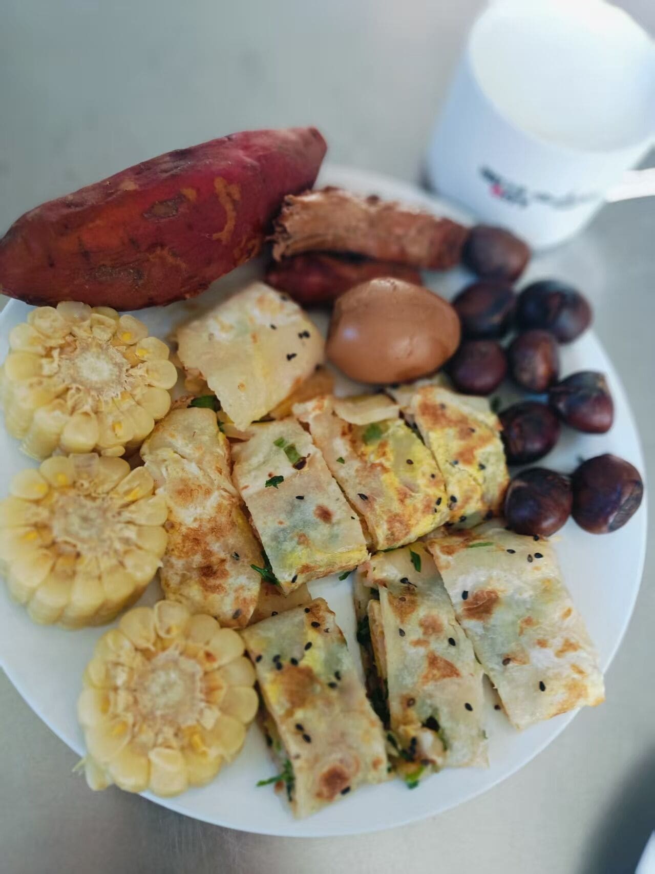 Une assiette contenant des patates douces, du maïs et d’autres légumes.