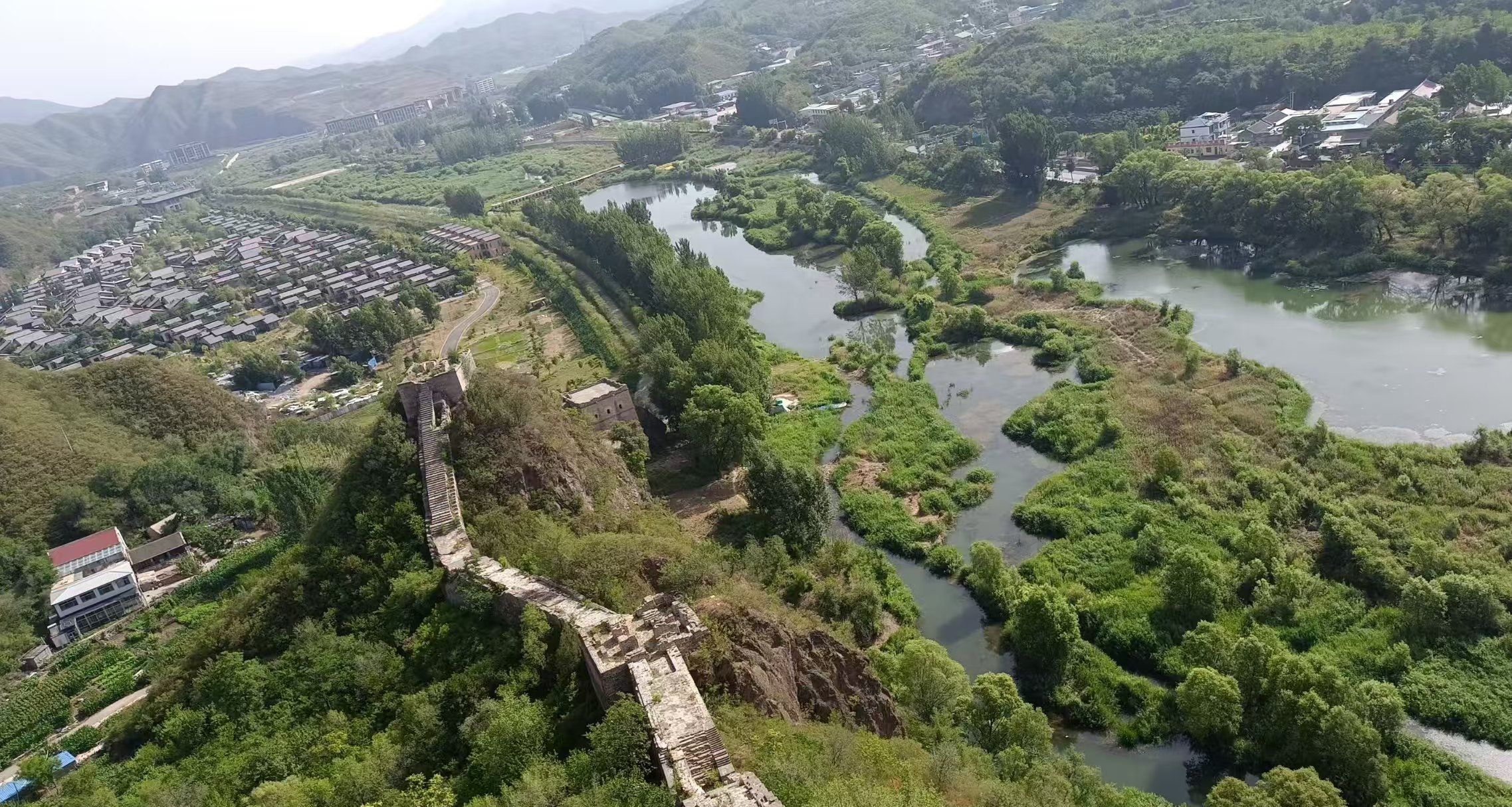 Vue aérienne d’un site historique, avec ses ruines antiques, une rivière et la végétation luxuriante qui l’entoure.