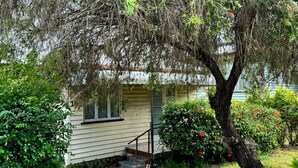 A house with a front porch, a small staircase, and a tree with red flowers. - Affordable Chermside Home near Hospital & Westfield (Chermside)