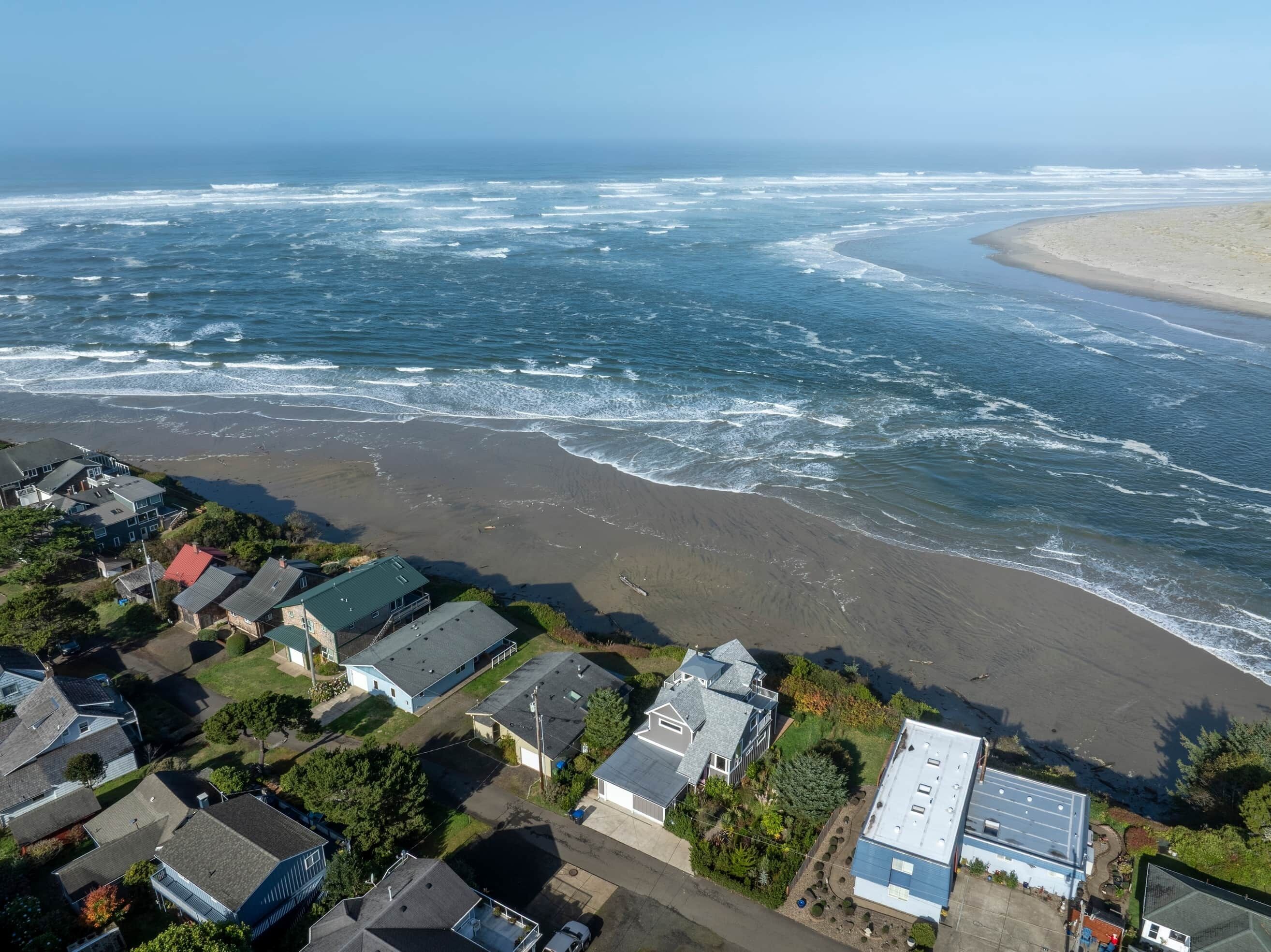 Et kystnært boligområde med huse tæt på strand og hav.