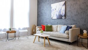 Ein Wohnzimmer mit einer Couch, einem Couchtisch und einem Bild an der Wand.