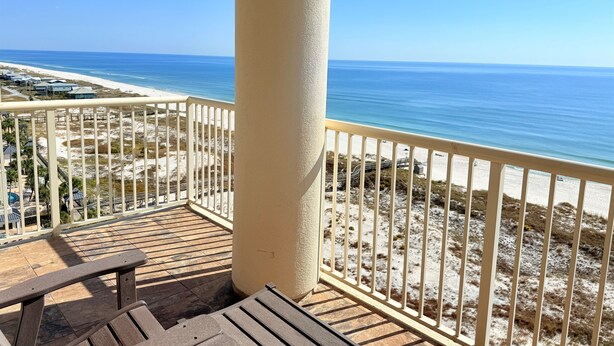 Un balcon avec vue sur une plage et l’océan.