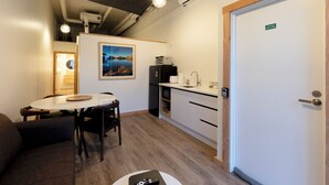 A modern kitchen with a dining area, a refrigerator, and a coffee machine. - Central Lofts 4 & 5 - Accessible - Brand New! (Queenstown)