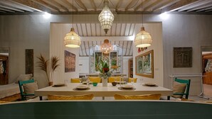 A dining area with a long table, yellow chairs, and hanging wicker lamps. - Villa Zen Bingin (Pecatu)