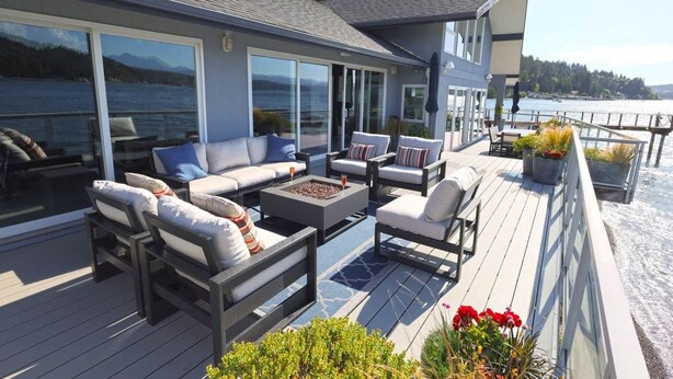 A deck with outdoor furniture, a fire pit, and potted plants. - Walls of Glass (Union)