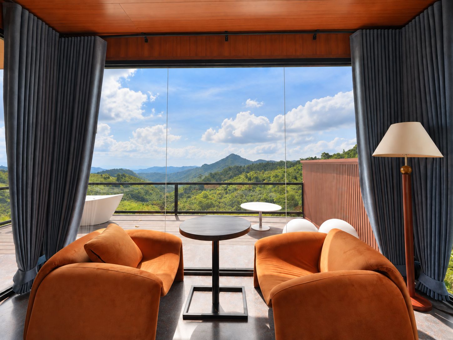 A modern room with a balcony, two sofas, a small table, and a lamp.