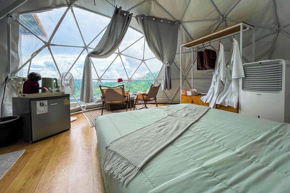 Ein geräumiges Zelt mit Bett, Sitzgelegenheit und Blick ins Freie.