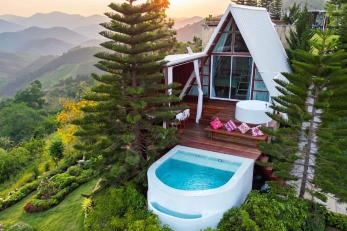 Ein modernes Haus mit Whirlpool, Terrasse und Bergblick.