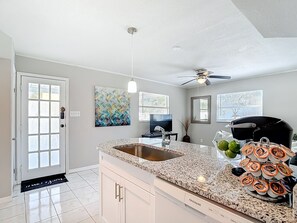 A kitchen with a granite countertop, stainless steel sink, and a black coffee maker. - Pool, Waterfront Community, Palmetto Beach 3 (Tampa)
