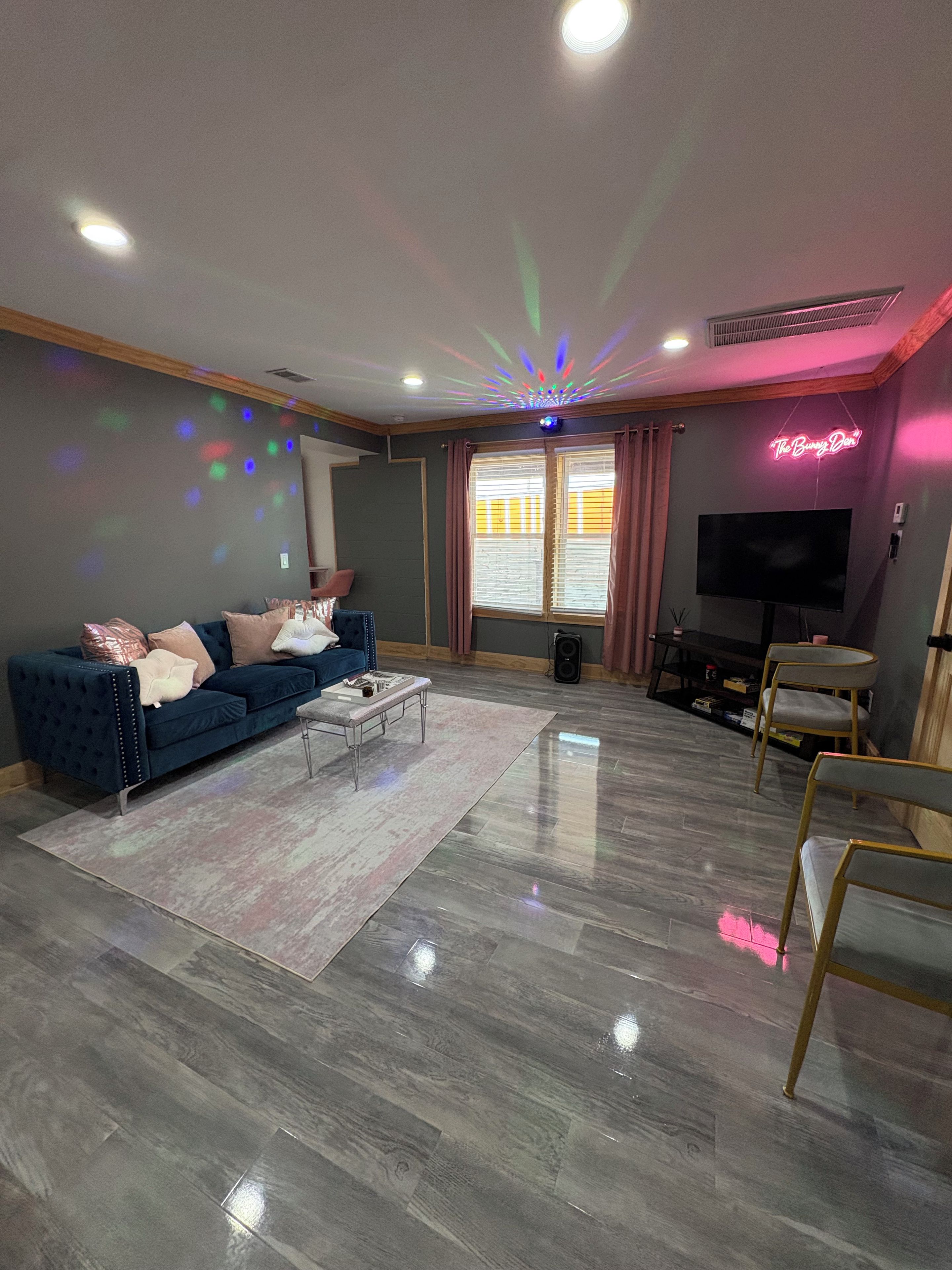 A modern living room with a blue sofa, a coffee table, and a flat-screen TV.