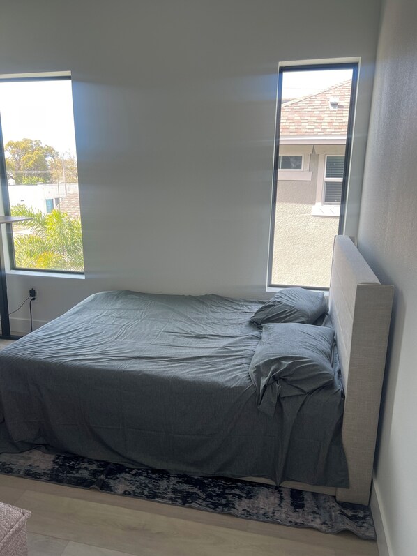 A bedroom with a bed, a window, and a view of the outside. - 1 mile to Downtown St Petersburg new construction luxury 2,155 sqft home (St. Petersburg)