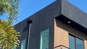 A modern building with large windows, a balcony, and a street lamp. - 1 mile to Downtown St Petersburg new construction luxury 2,155 sqft home (St. Petersburg)