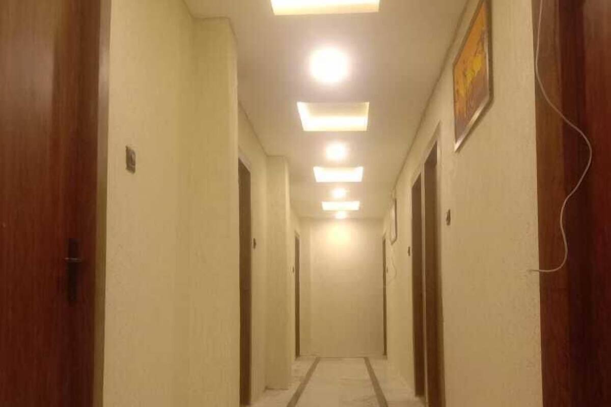 A hallway with wooden doors, a marble floor, and recessed ceiling lighting.