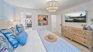 A bedroom with a bed, a dresser, a chandelier, and a painting of a turtle. - 🌸Posh Bungalow 🌴near Anna Maria Beaches, IMG and LECOM (Bradenton)