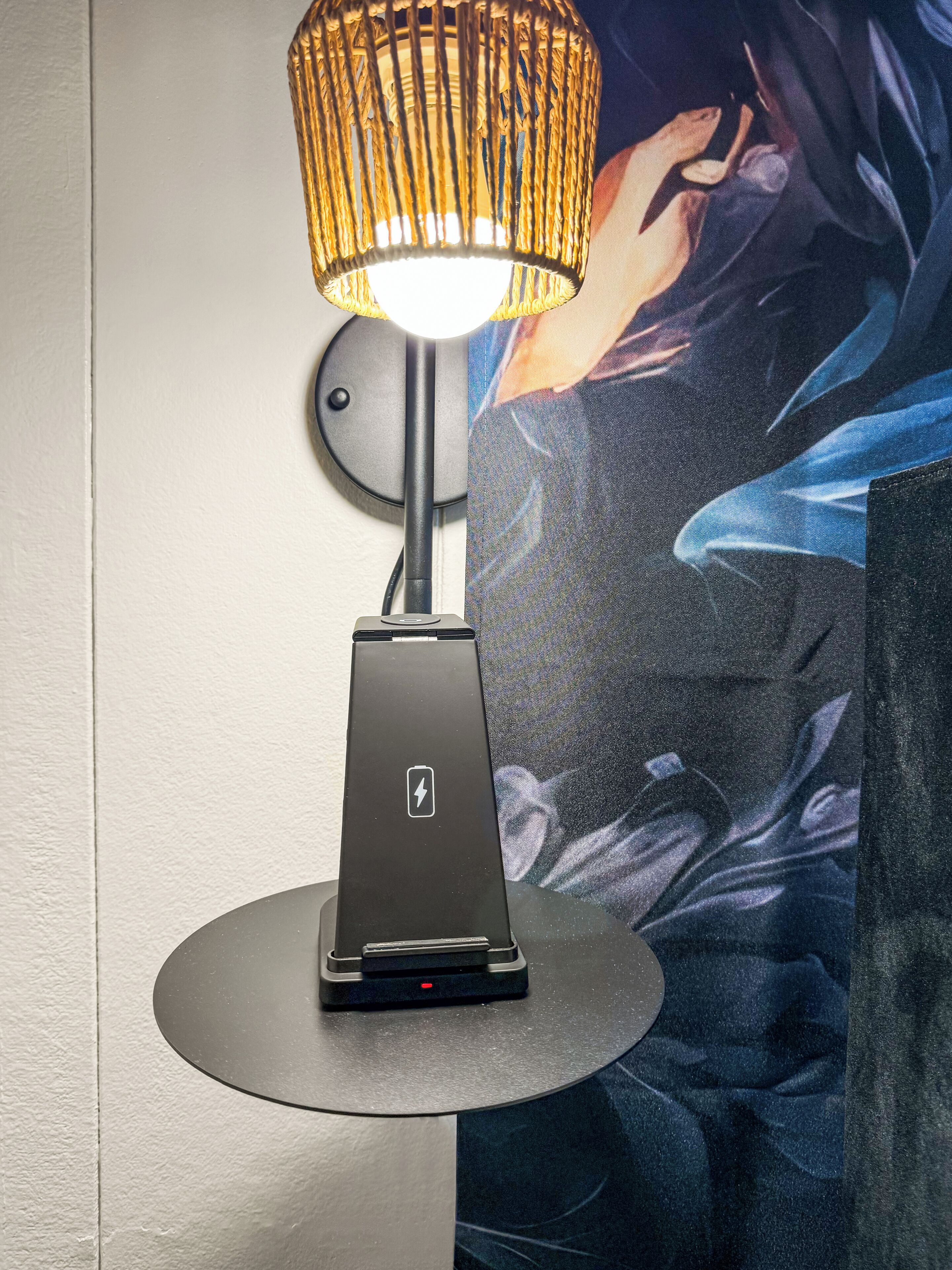 A modern lamp with a circular base and a textured shade, placed on a round table.