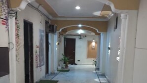 A corridor with marble flooring, white walls, and a ceiling with recessed lighting. - Hotel Manglam Inn (Lucknow)