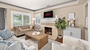 Una sala de estar con chimenea, televisor y sofá.