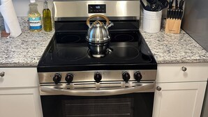 A kitchen with stainless steel appliances, including a microwave, stove, and oven. - Livie’s Cozy Cottage Near Collierville (Olive Branch)