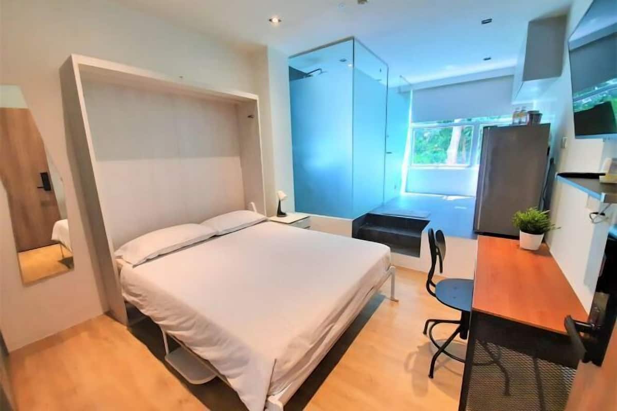 Une chambre à coucher moderne, avec un lit, un bureau et une armoire.