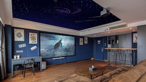 A modern living room with a starry ceiling, a large flat-screen TV, a wooden coffee table, and a leather sofa. - LiangZhi Huipin Hotel (Haikou)
