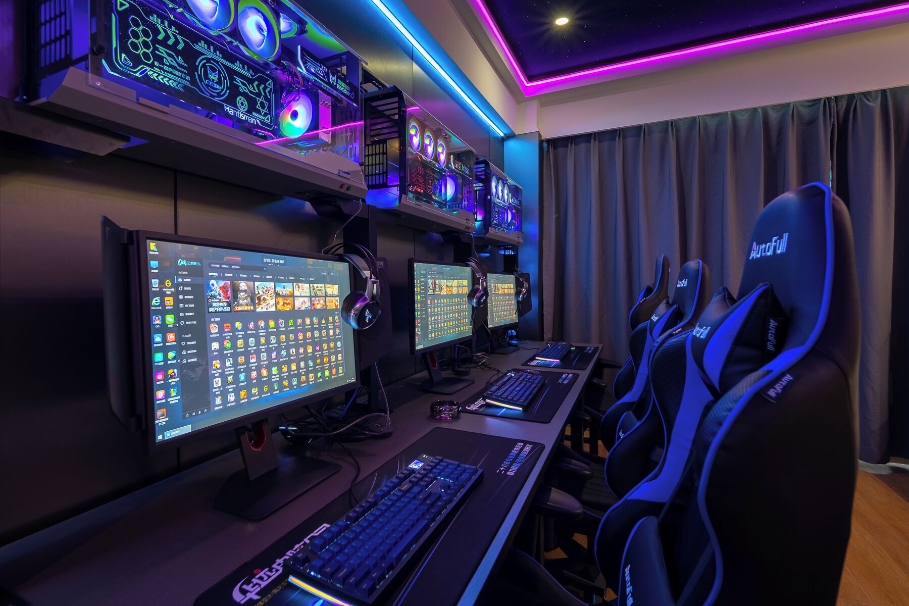 Configuración para juegos con dos monitores, un teclado y sillas gamer.