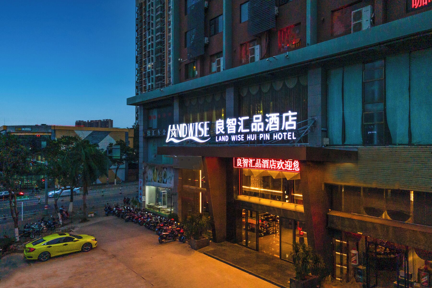 A hotel with a prominent sign reading "Land Wise Hui Pin Hotel".