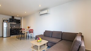 Um apartamento moderno com sala de estar, cozinha compacta e espaço para refeições.