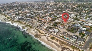 An aerial view of a coastal town with a prominent red marker indicating a specific location. - Modern 2BR Near Beach w/ Parking, Spa, BBQ, EV (San Diego)