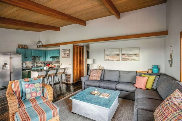 A living room with a sofa, coffee table, and a dining area with chairs and a table.