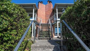Una scala conduce a un edificio con facciata in mattoni e ringhiera in metallo.
