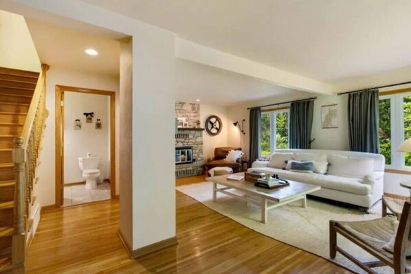 A spacious living room with a white sofa, a coffee table, and a fireplace. - Waterfront Home|Dock & Kayaks|5 Min to Baileys Harbor (Baileys Harbor)