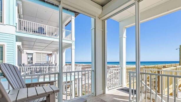 A balcony with a view of the beach and ocean.