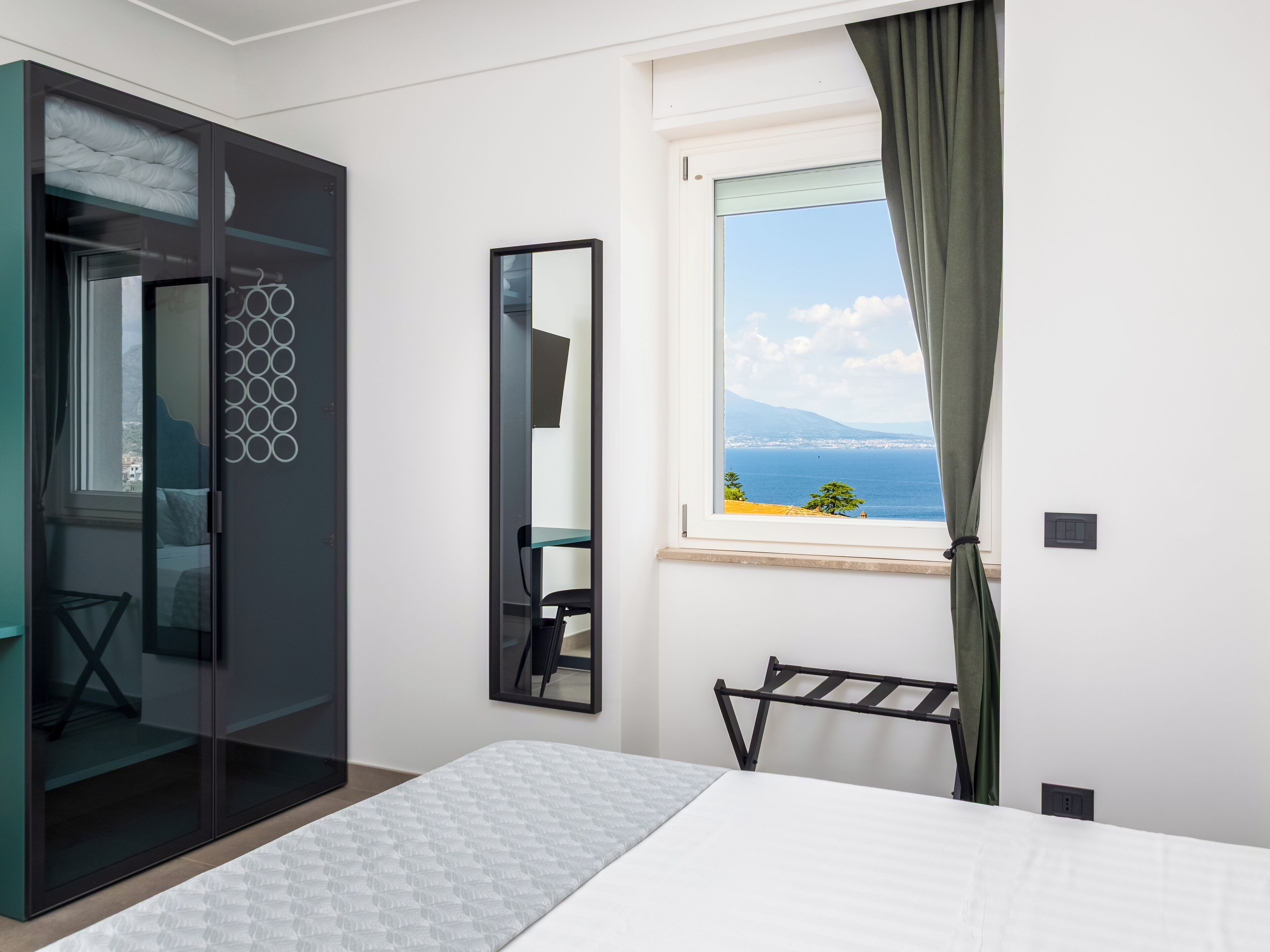 Appartamento panoramico, vista mare | Una scrivania, postazione laptop, tende oscuranti, ferro/asse da stiro