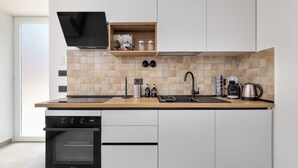 A modern kitchen with a built-in oven, a sink, and a coffee maker. - Maison Regina Giovanna (Sorrento)