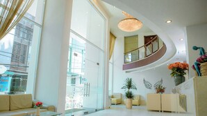 A spacious lobby with a glass coffee table, a sofa, and a reception desk. - Lanxy Nha Trang (Nha Trang)