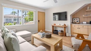 Un salon moderne avec un canapé, une table basse et un téléviseur fixé au mur.