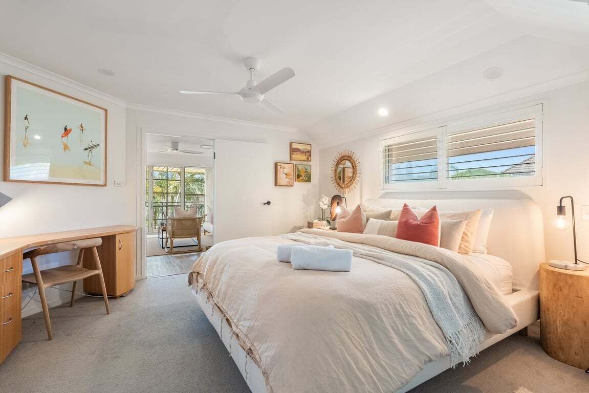 A bedroom with a large bed, a desk, and a ceiling fan. - Sabera - Penthouse in the heart of Byron Bay (Byron Bay)