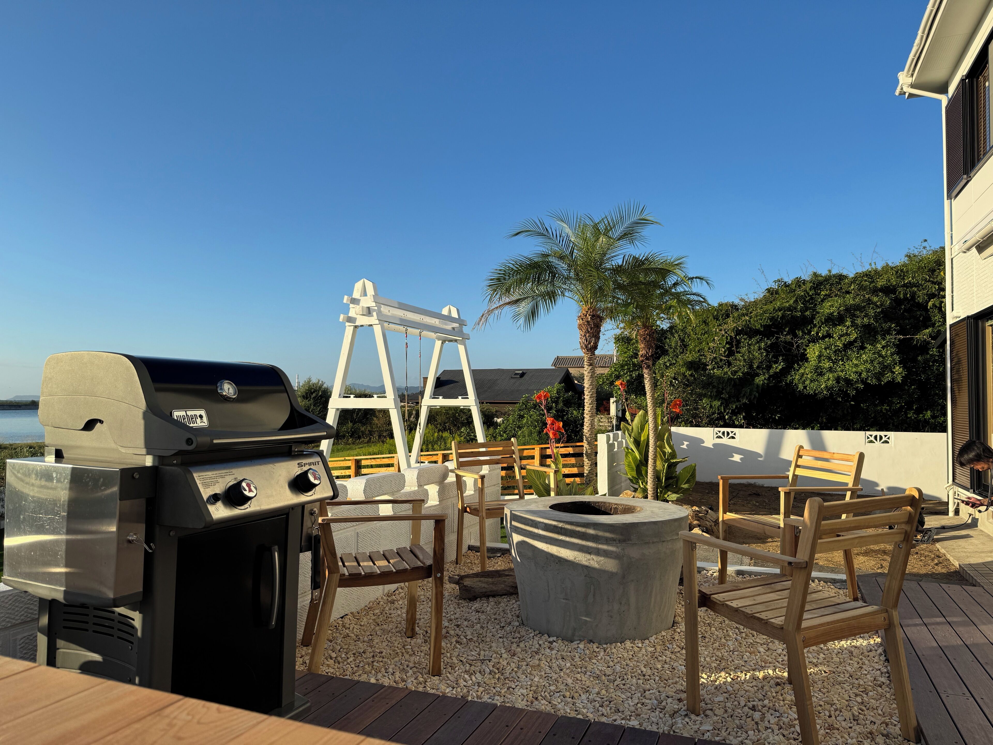 A patio with a grill, seating, and a fire pit.