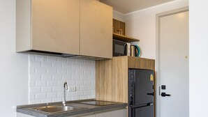 Una cocina moderna con una isla integrada, pileta de acero inoxidable y refrigerador negro.