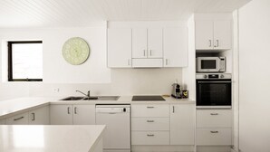 A modern kitchen with white cabinetry, a sink, a microwave, and an oven. - Tea Trees 5 - Coastal Calm near Hastings St (Noosa Heads)