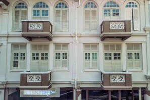 A multi-story building with balconies, a shop at the ground level, and a sign that reads 'BUTTERNUTTREE.' - Butternut Tree Hotel (Singapore)