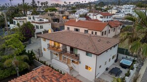 A residential area with houses featuring red-tiled roofs, balconies, and a swimming pool.