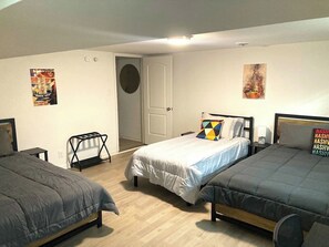 A room with two beds, a small table, a chair, and a door. - Paradise Found with Pool and Hot Tub (Nashville)